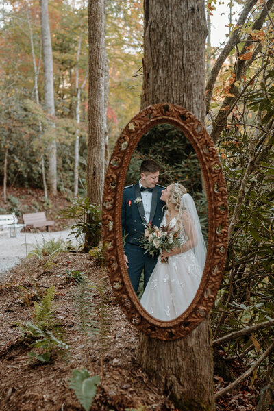 reflection in a mirror of bride and groom smiling at each other