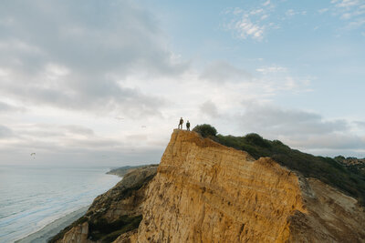 bride and groom on ocean cliff
