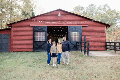 Family posed and smiling with buildings in the backgrou
