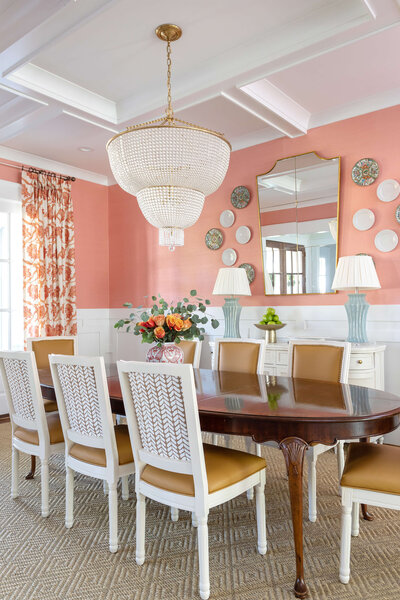 Dining space with orange walls and chandelier