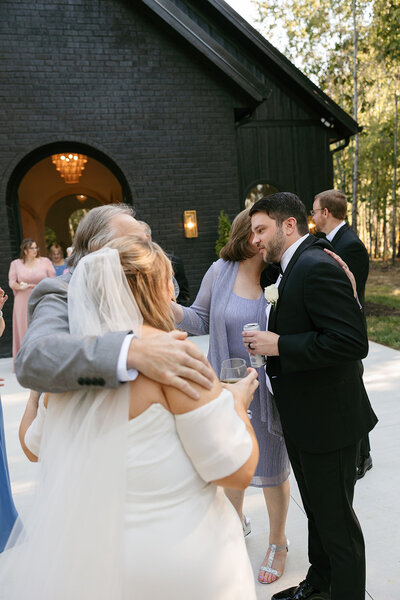 Bride and groom hugging their family at Nashville wedding