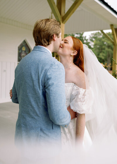 Newly married couple embracing in front of a church in Wilmington, elegant wedding photography