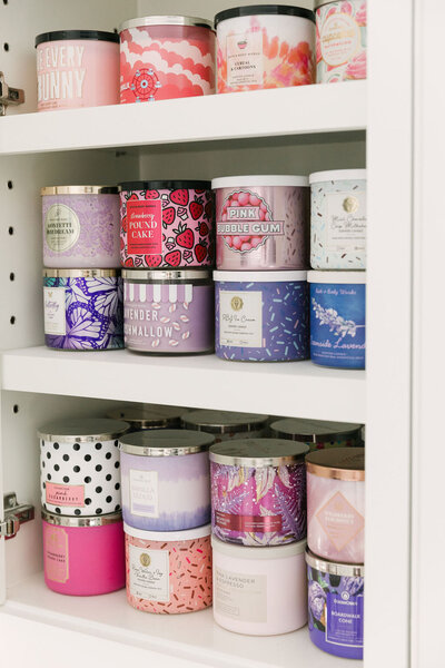 Bath and Body Works candles organized in a kitchen cabinet