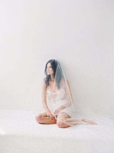 bridal boudoir photo with veil in all white studio on film