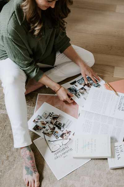 Erika Fitzgerald sitting on the floor examining papers for a website copywriting project