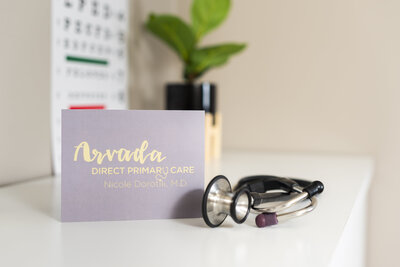 doctor's business card sitting beside a stethoscope