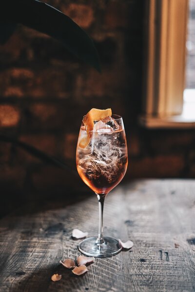 Aperol Spritz cocktail with orange peel on rustic table