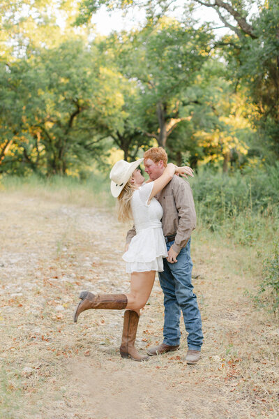 texas bride embracing fiance in cowboy boots