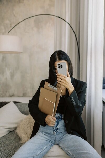 An employee from Kmotion, a Showit website designer, using her computer and phone.