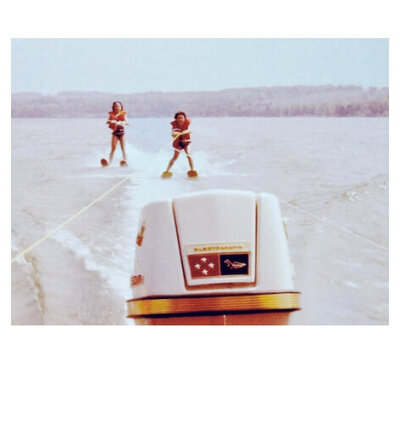 Skiers being pulled by old speed boat