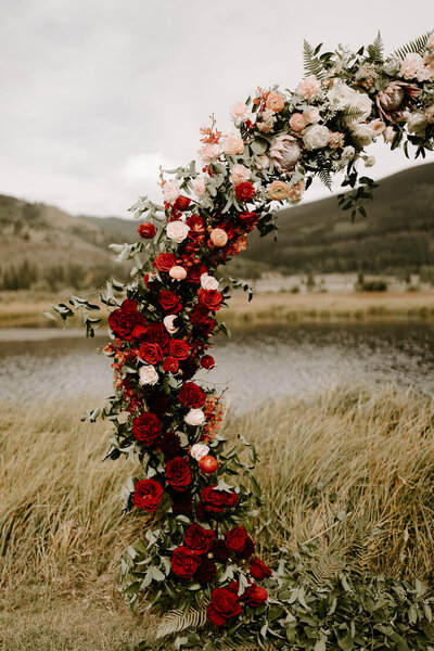 Custom red and white arbor floral arch for an outdoor Chinese Fusion wedding