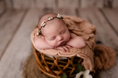 Lansing Newborn Photographer Baby Laying on Hands in Basket by For the Love of Photography