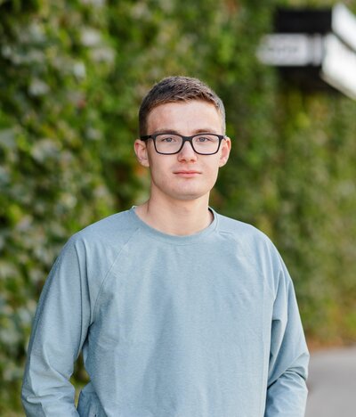 High School Senior in front of green ivy wall in Downtown Fargo