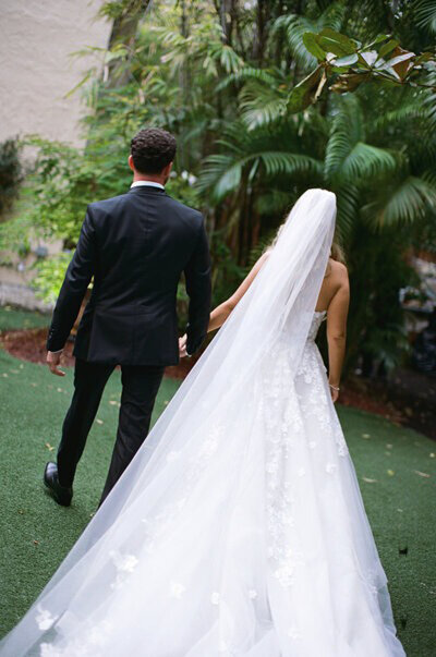 Bride and groom holding hands and walking by Orlando Wedding Photographer Marissa Nicole Photography