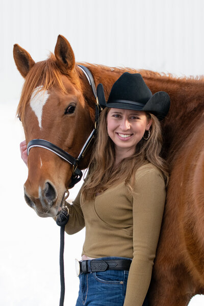 Woman in cowboy hat poses with her heart horse