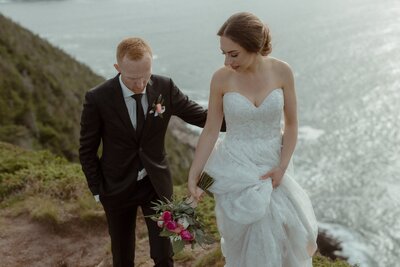 bride and groom explore a sea cliff in Newfoundland