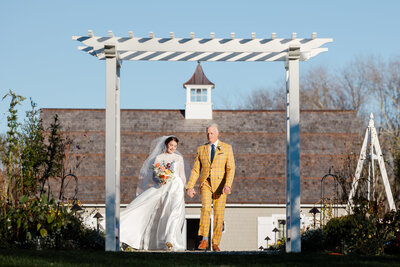 Bride and father walk down aisle.