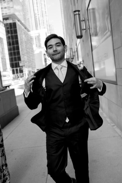 An editorial style groom walking with his jacket open in Chicago, Illinois. 