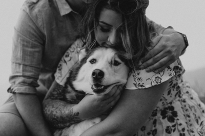 black and white image woman cuddling a husky