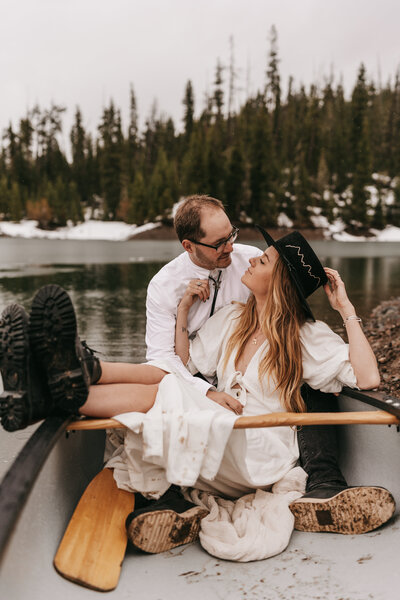 A couple poses in a canoe on their elopement day.