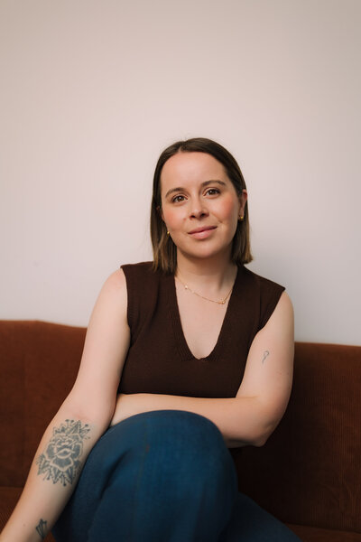 Liv Rollings sitting on rust colored couch