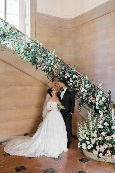 Groom embraces his bride who holds her wedding bouquet