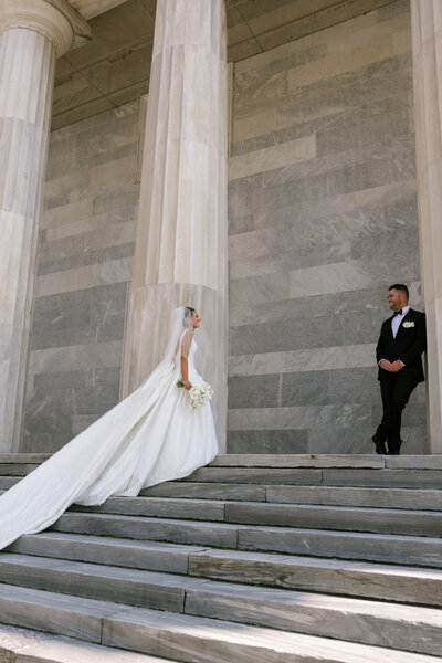 Close up view of delicate wedding dress skirt, wedding bouquet, and heels