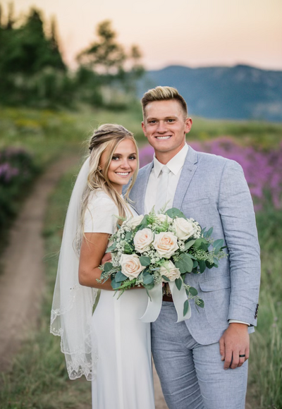 Bride and groom looking at each other bride holding bright bridal bouquet