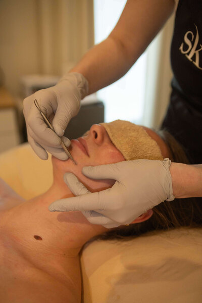 Client receiving a facial at Maven + Grace Salon in McMinnville, Oregon, with gloved esthetician applying eye treatment and mask