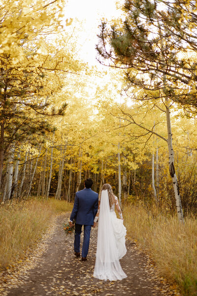 photo of groom embracing bride from behind while they both smile with red rock formations in the background taken by Elopement photographer in breckenridge