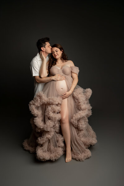The expectant mother stands alongside her husband, both radiating love and anticipation for their growing family. Captured during a maternity session by Inland Empire photographer Kaitlyn Dawn Photography.
