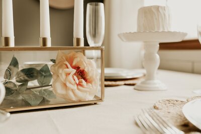 close up of an elegant table setting with a flower, champagne flute, and candle