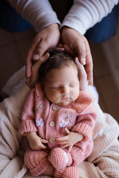 New parents are holding their newborn baby boy during their newborn photography session in Tucson