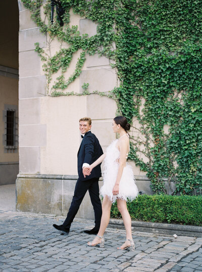 groom walking bride in courtyard at oheka castle