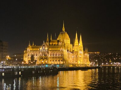 Nighttime view of the Parliament building in Budapest, Hungary lit up, taken from a river cruise ship on the Danube River. 