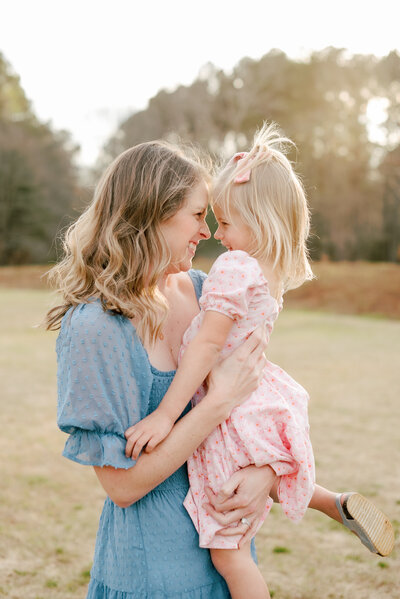 Mom and daughter laughing in a field during a family photography session in Raleigh NC. Photographed by Raleigh family photographers A.J. Dunlap Photography.