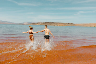 Couple running into the lake in Utah