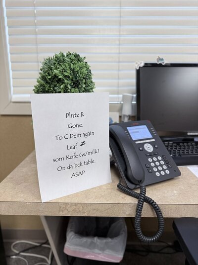 Sign that says "Plants R Gone, Must Bring Back Coffee for the Office to Get Back"