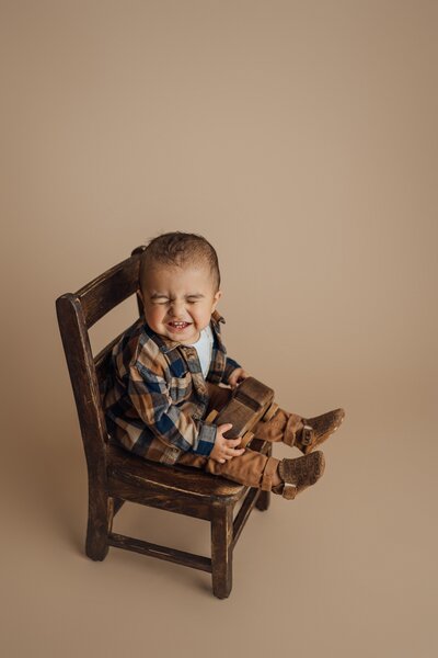boy sitting on chair during first birthday session in tampa