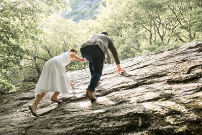 bride and groom climbing rock
