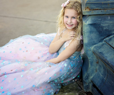 Girl portrait in gown leaning on post