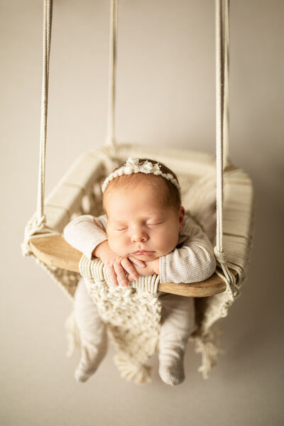 sleeping newborn in a swing