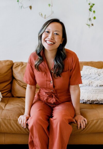 Asian calligrapher business owner sitting on leather sofa