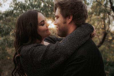 A couple embraces at sunset.