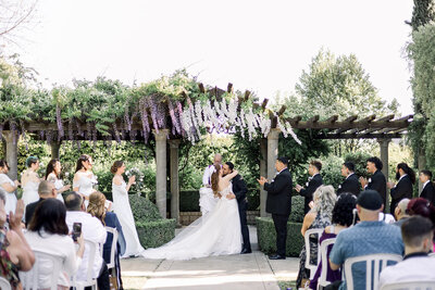 Bride and groom share a first kiss at their English Garden ceremony