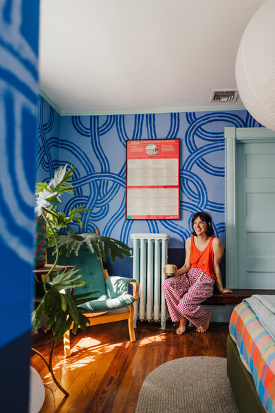 interior designer with colorful style drinks coffee in bedroom