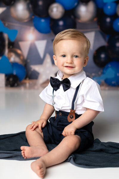 one year old boy posing for first birthday photoshoot in studio cleveland cake smash photographer