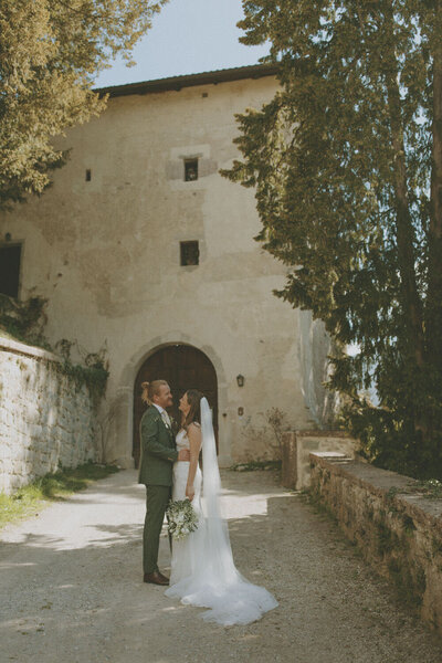 bride and groom looking at each other in front of castle: vancouver wedding photographer