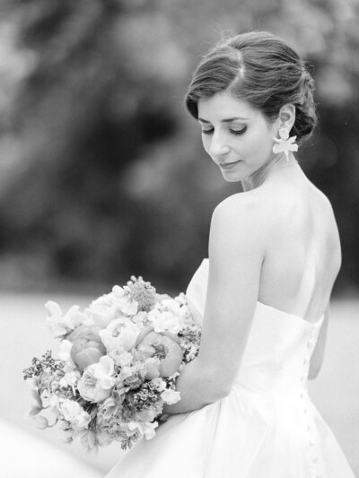 black and white portrait of bride looking over shoulder with floral bouquet