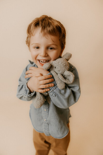 Photo of Morgan's 4 year old son holding his favorite stuffed animal elephant for a photo in the studio.